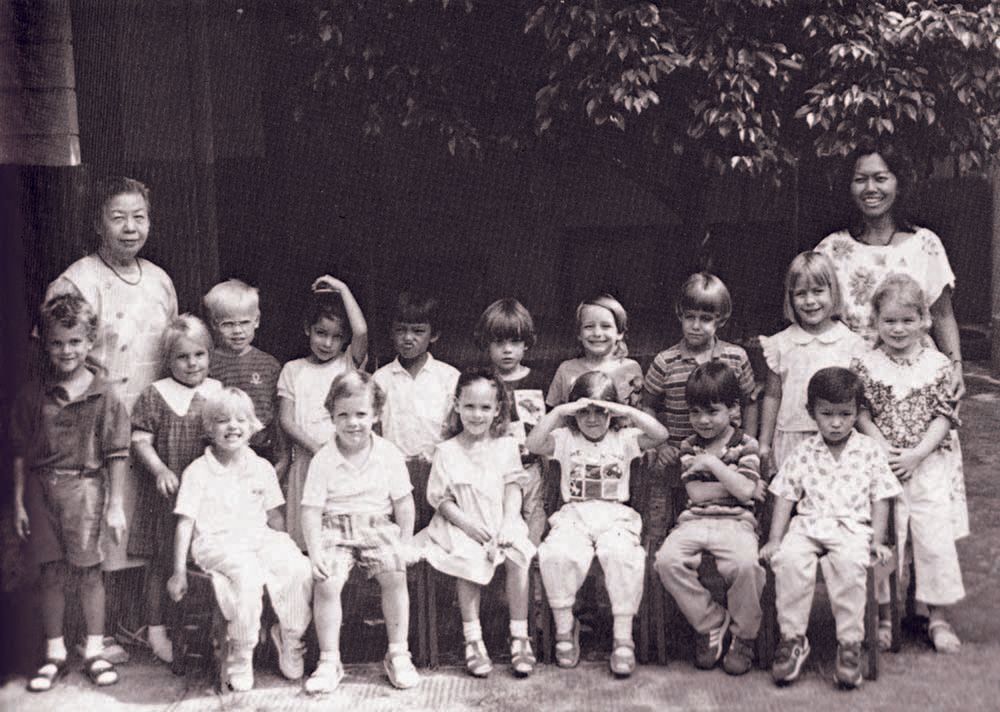 A group of children are posing for a picture with their teacher