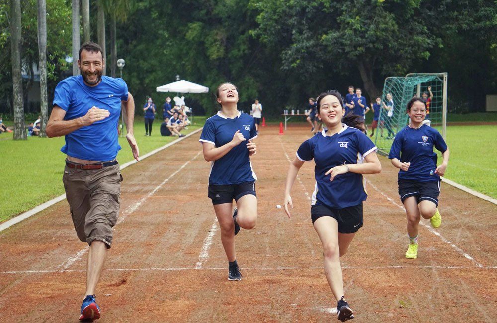 A group of people are running on a track.