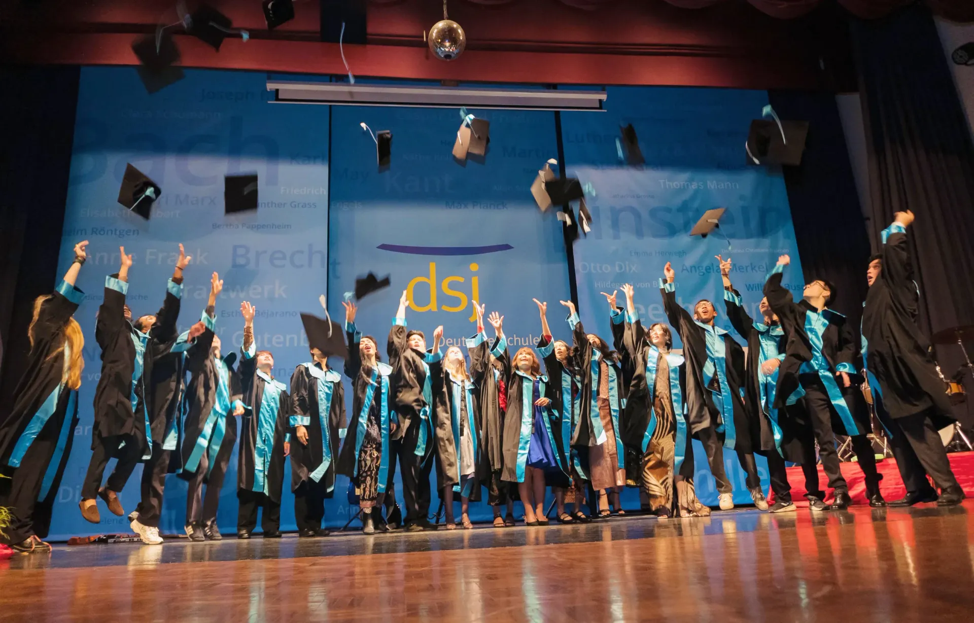 The DSJ Abitur Graduates of 2026 celebrate on stage throwing their graduation caps
