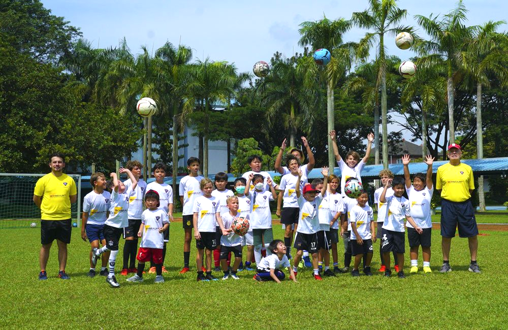 A group of children are posing for a picture on a soccer field