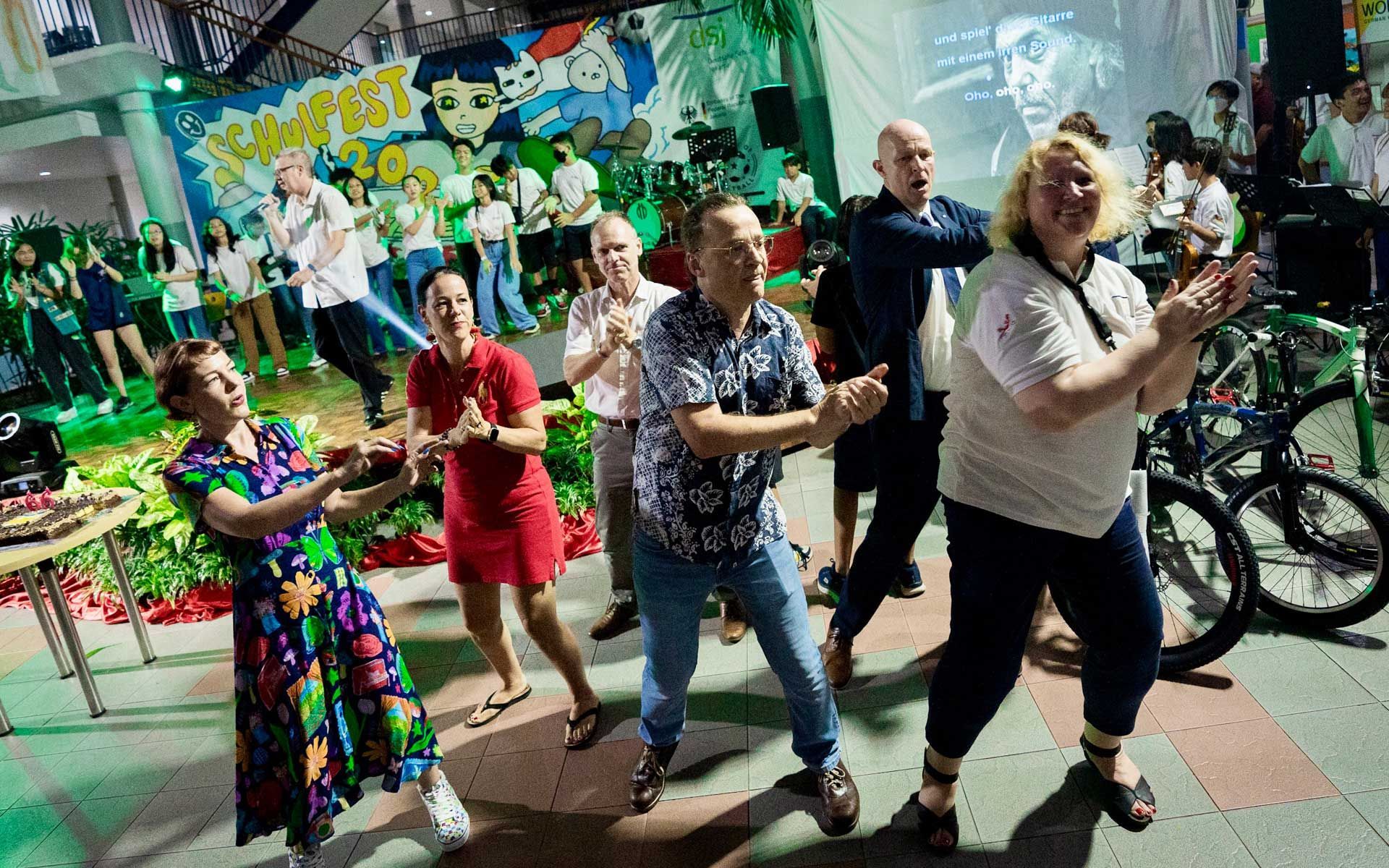 A group of people are dancing together in a room.