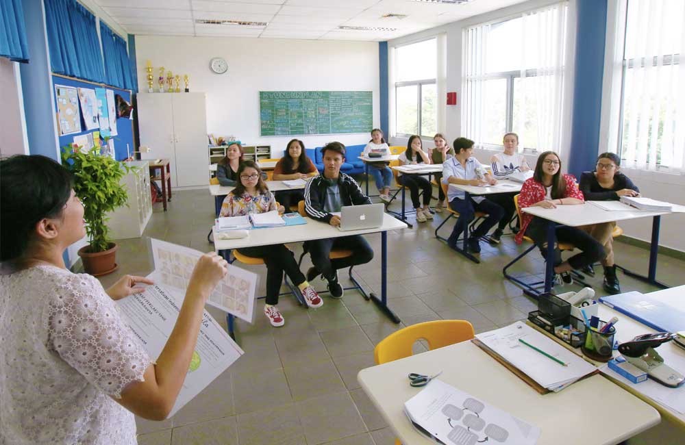 A teacher is giving a presentation to her students in a classroom.