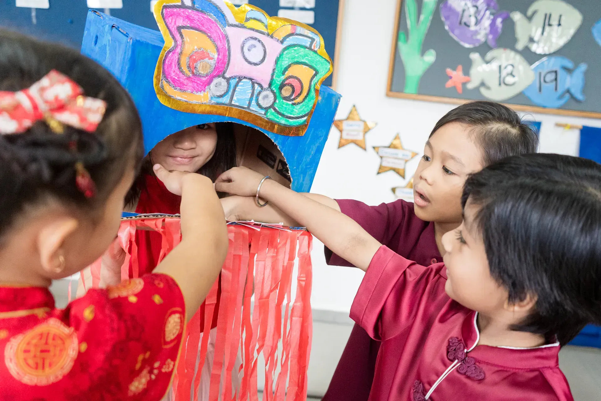 A group of children are playing with a puppet in a classroom.
