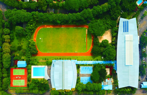 An aerial view of a soccer field surrounded by trees and buildings