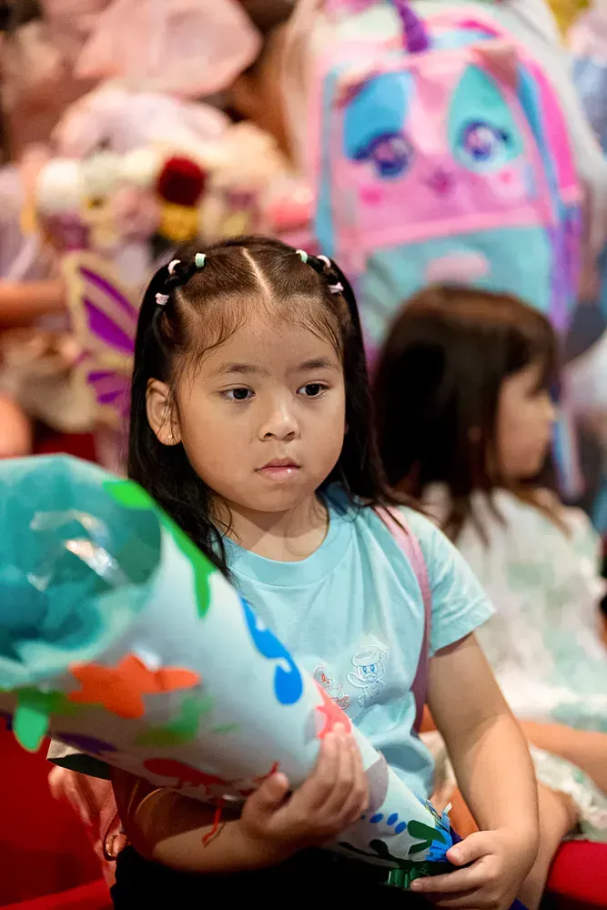 A little girl is holding a stuffed animal in her hands.