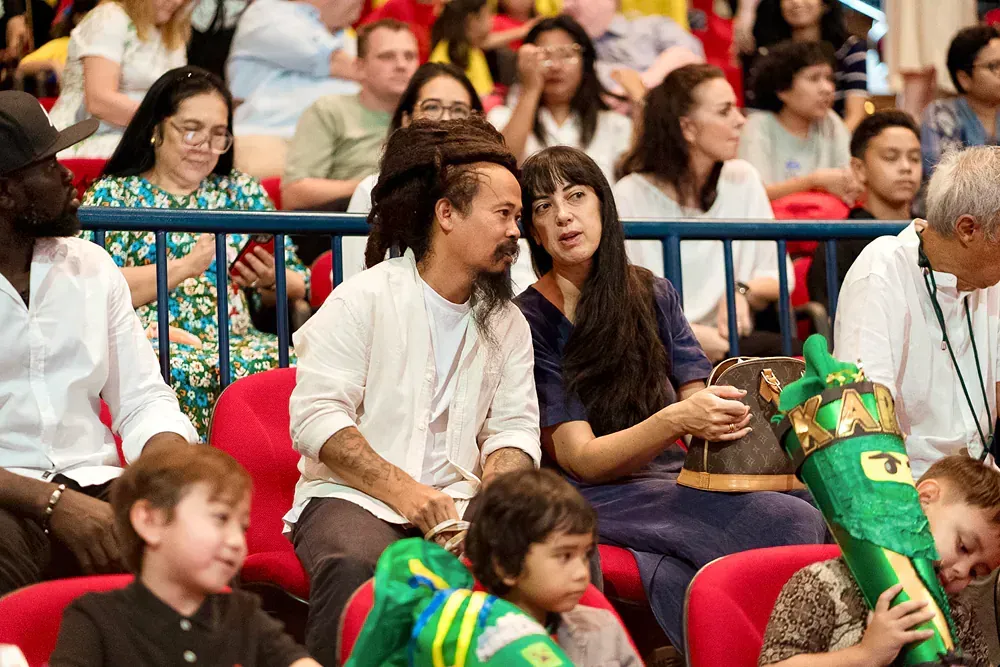 A group of people are sitting in a stadium watching a game.