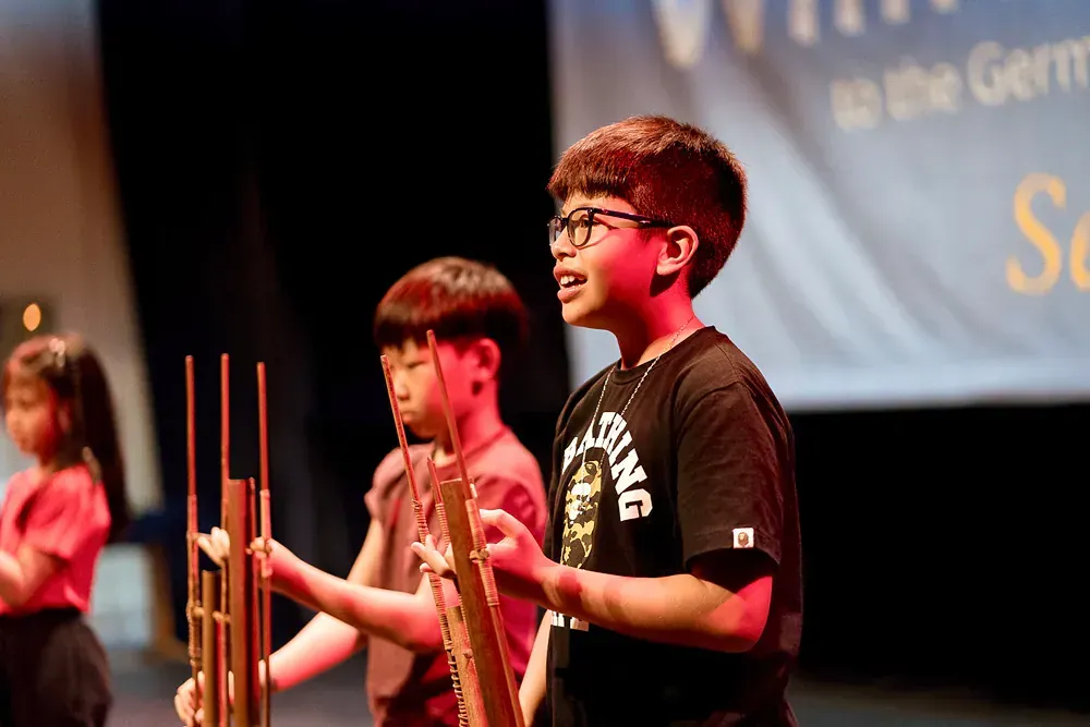 A group of children are playing instruments on a stage.