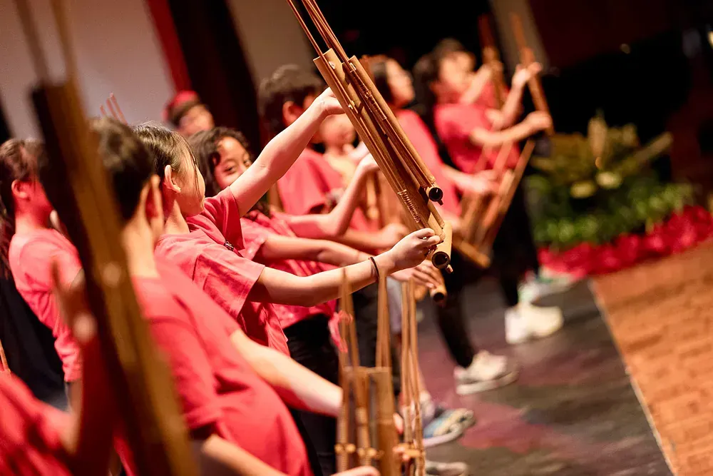 A group of children are playing instruments on a stage.