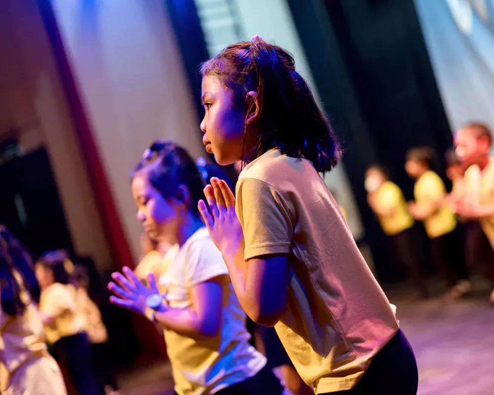 A group of young girls are dancing on a stage.