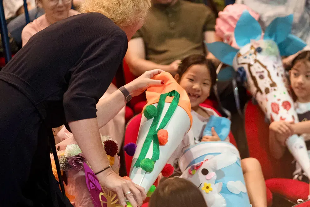 A woman is giving a cone to a child.