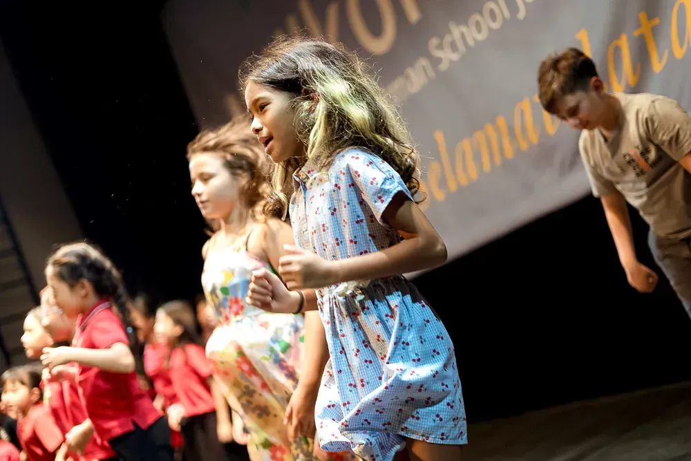 A group of children are dancing on a stage.