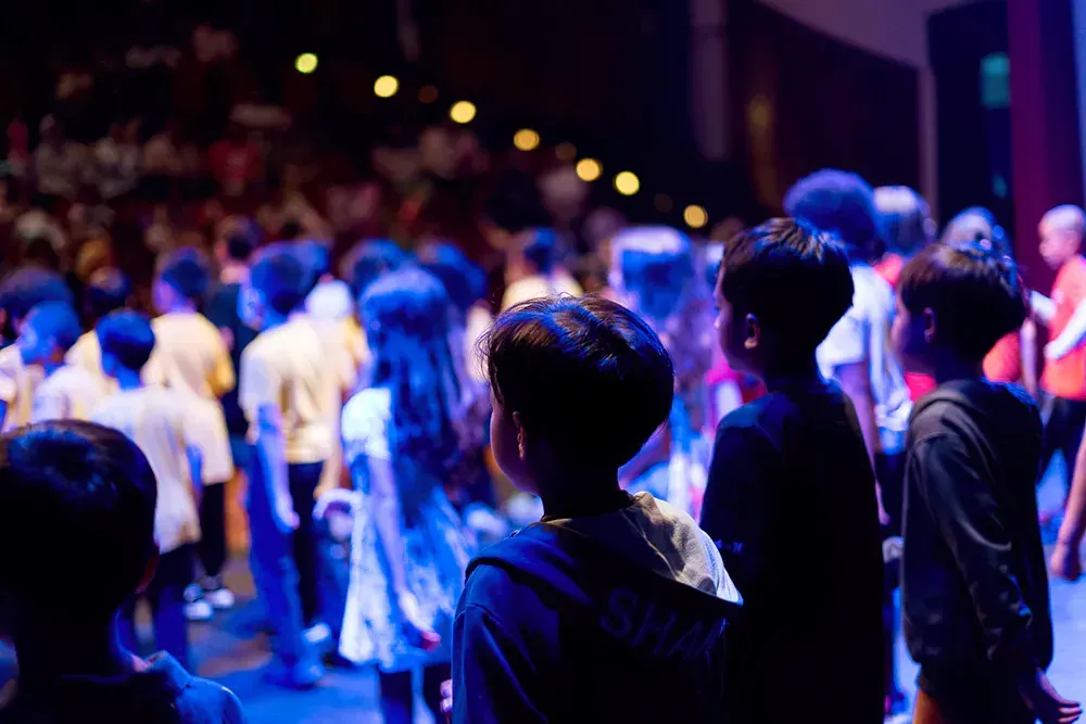 A group of people are standing in a dark room.