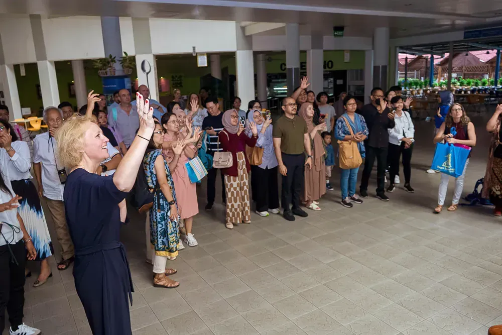 A woman is taking a picture of a group of people standing in a room.