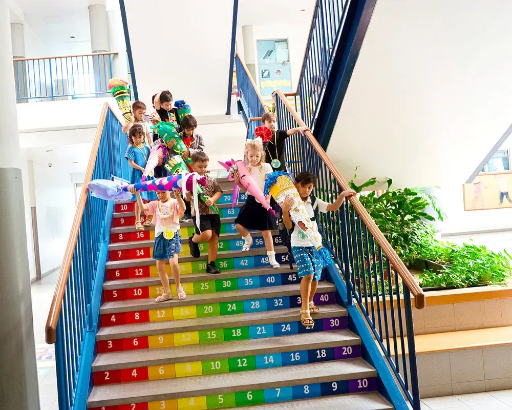 A group of children are walking up a set of colorful stairs.
