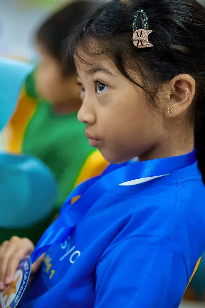 A little girl wearing a blue shirt with the word nyc on it
