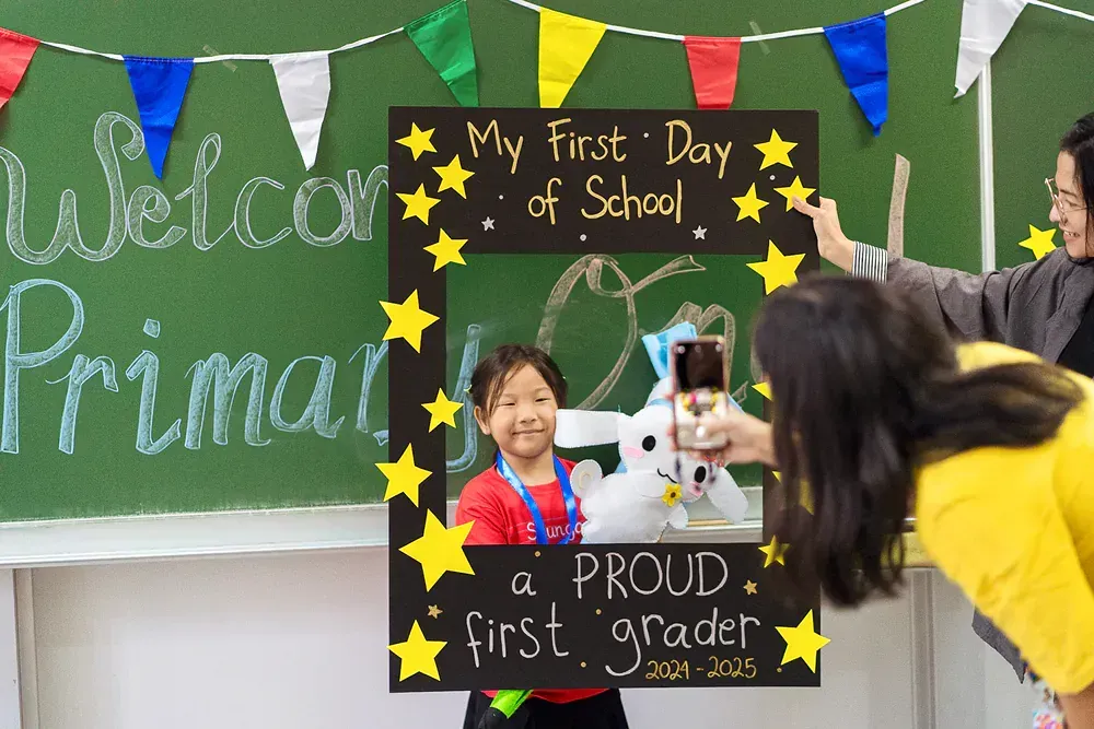 A girl is taking a picture of her first day of school