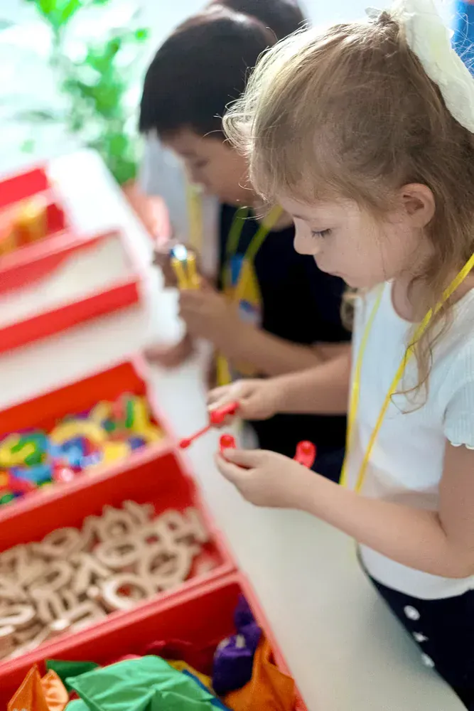 A group of children are playing with toys at a table.
