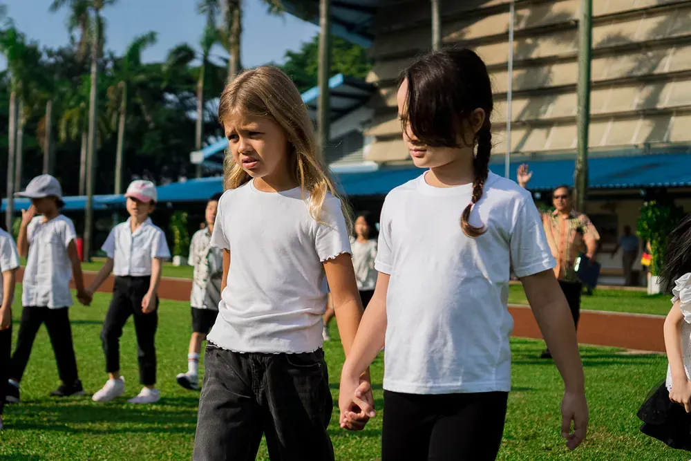 A group of children are holding hands in a field.