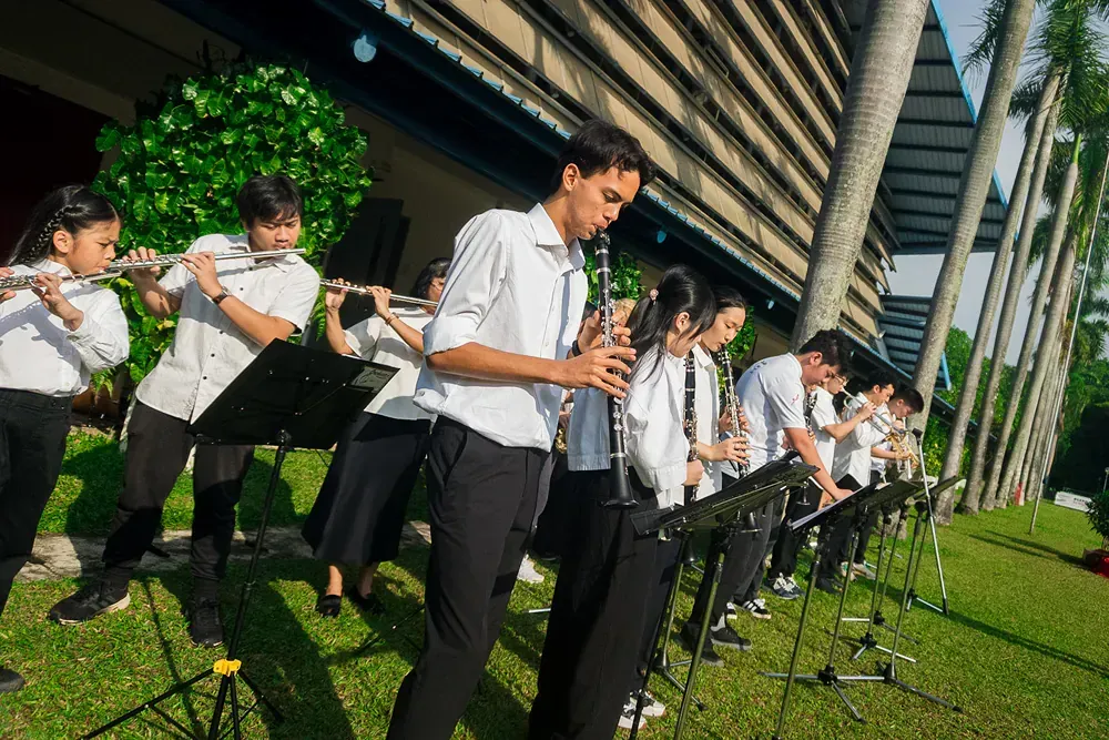 A group of young people are playing instruments in front of a building.
