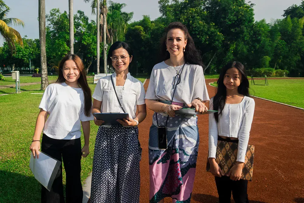 A group of women are standing next to each other in a park.