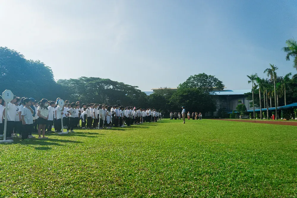 A large group of people are standing in a grassy field
