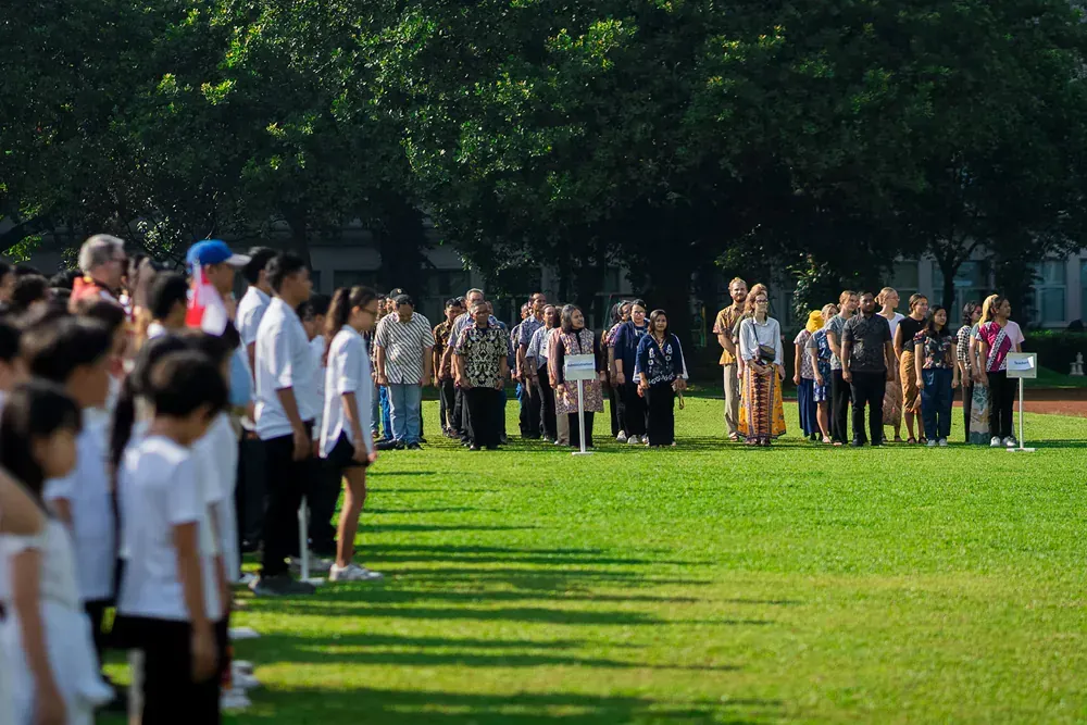 A large group of people are standing in a field.