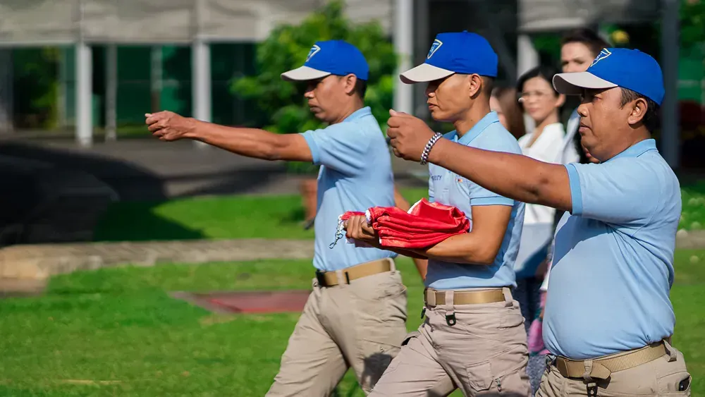 A group of men in blue shirts and hats are walking down a grassy field.