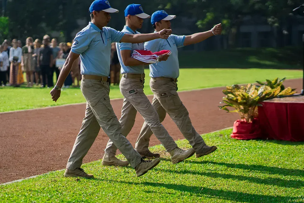 A group of men in military uniforms are walking on a grassy field.