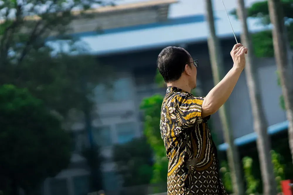 A man is flying a kite in front of a building.