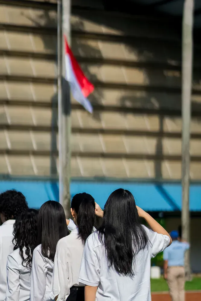 A group of people are standing in front of a flag.