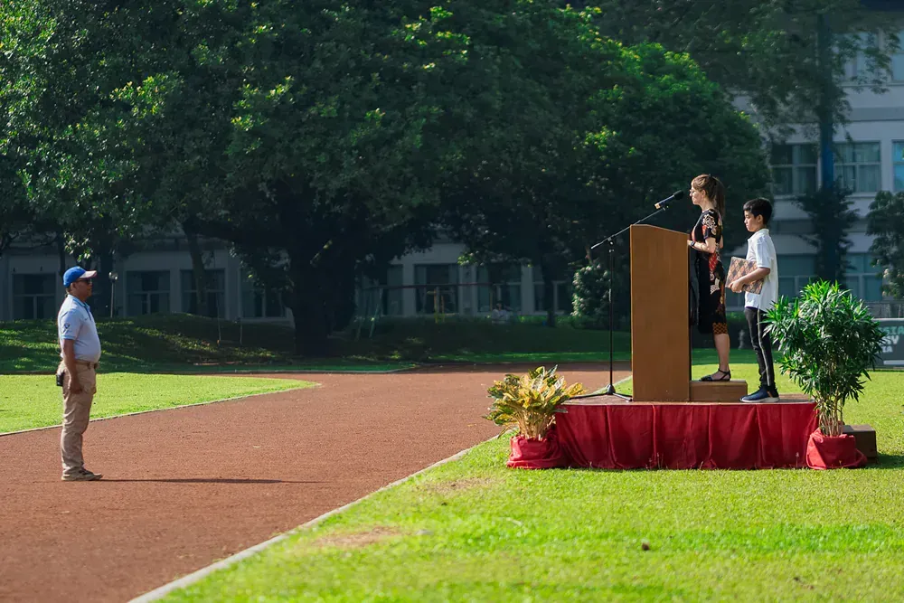 A group of people are standing at a podium in a field.