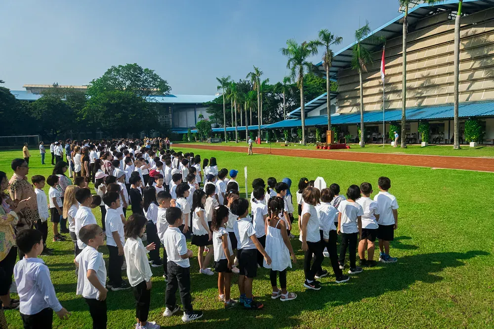 A large group of children are standing in a field.