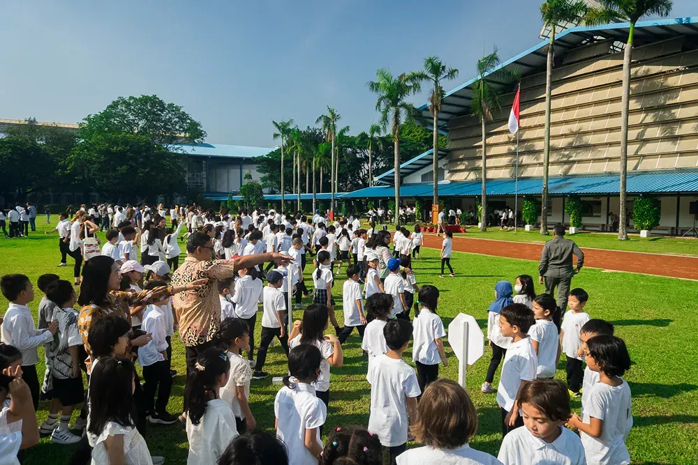 A large group of children are standing in a field.