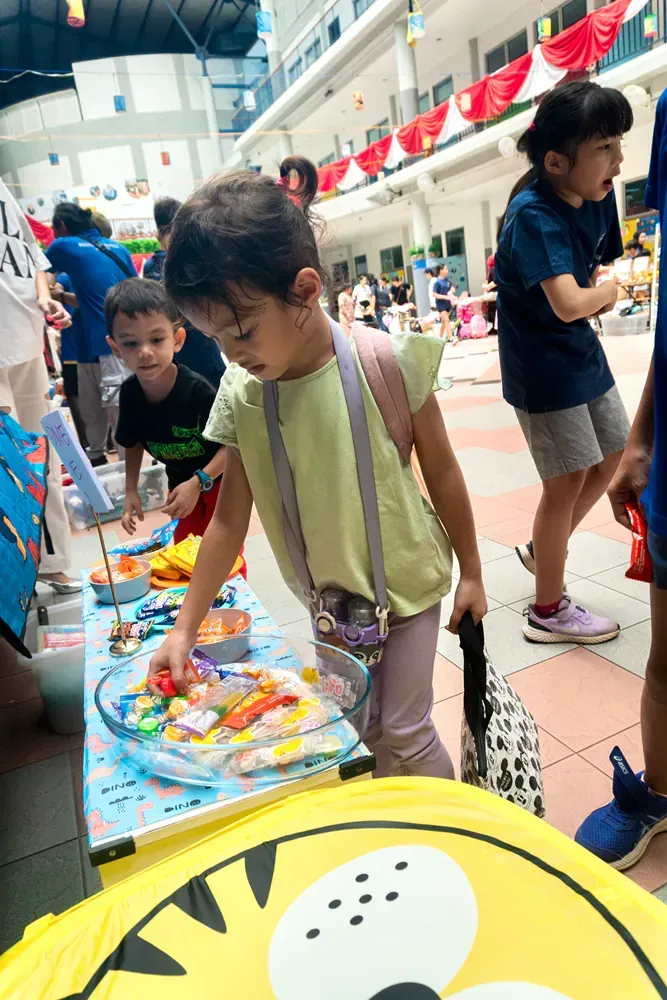 A group of children are standing around a table playing with toys.