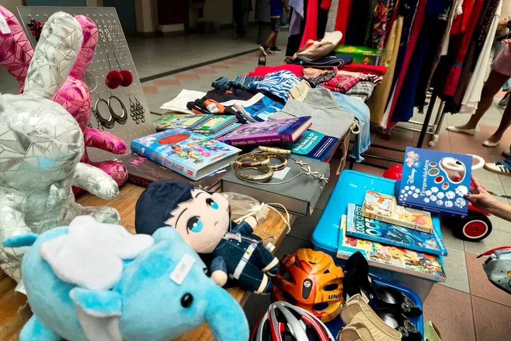 A table with a lot of stuffed animals and books on it.