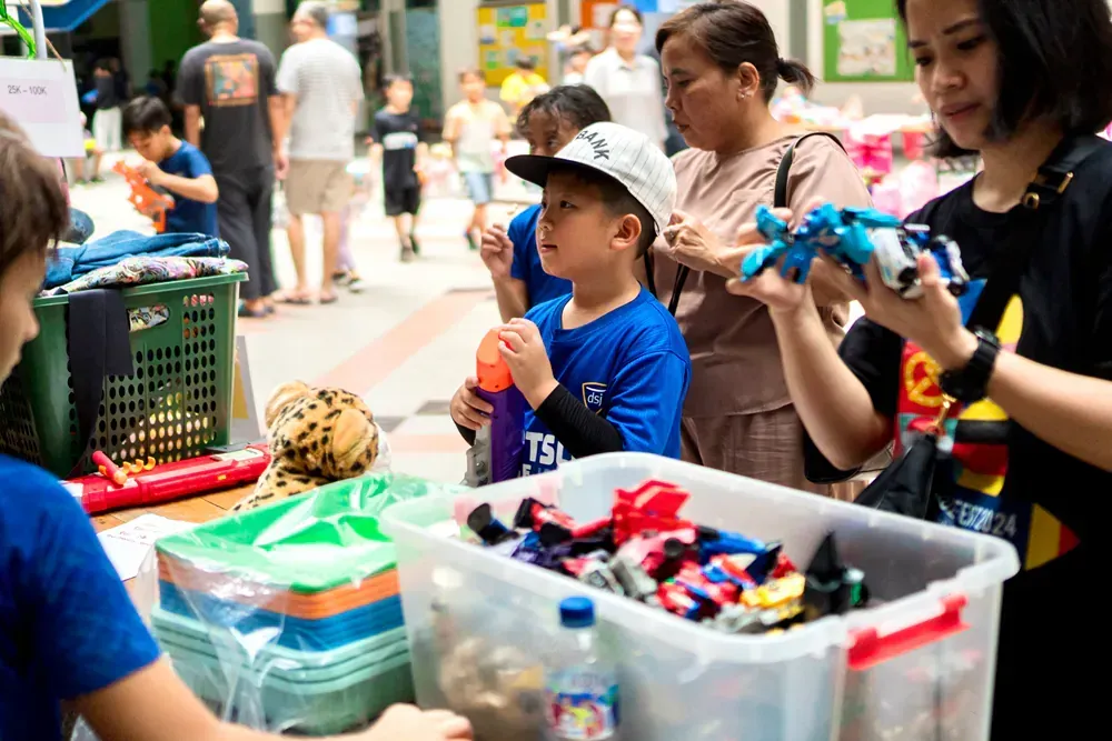 A group of people are standing around a table holding toys.
