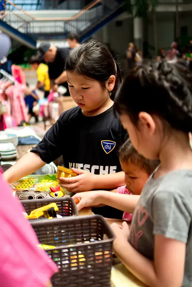 A group of young girls are playing with toys at a table.