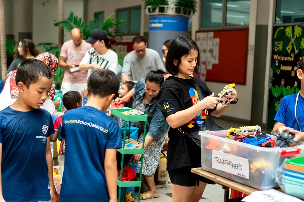 A group of children are standing around a table looking at toys.