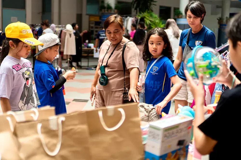 A group of children are standing around a table at a market.
