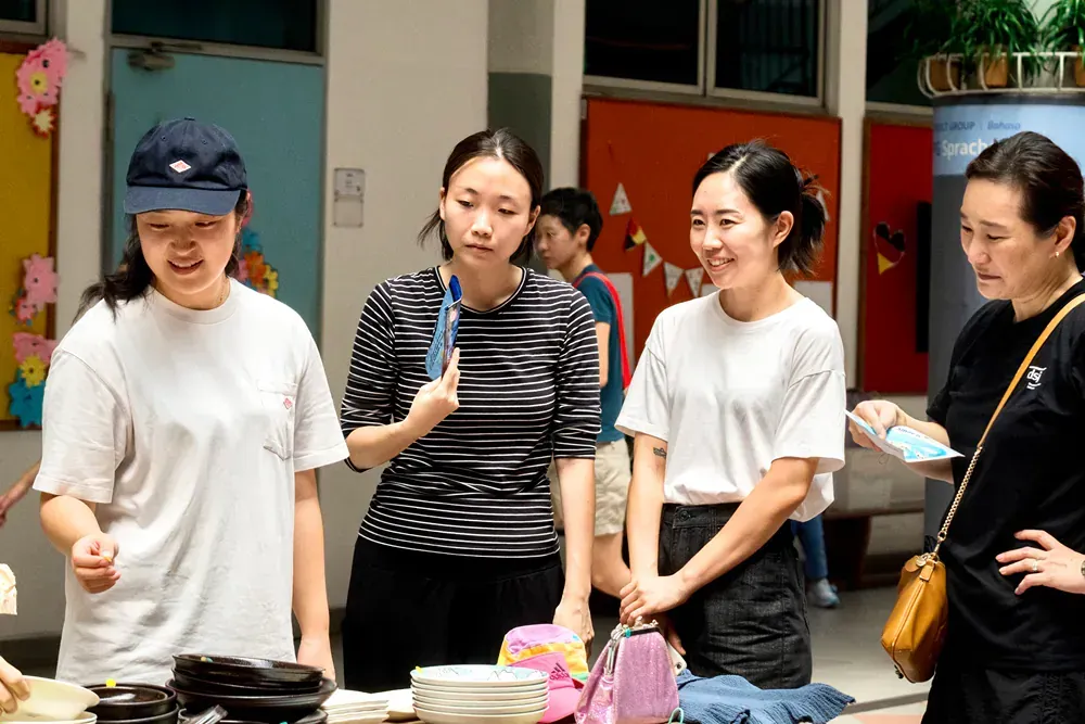A group of young women are standing around a table.
