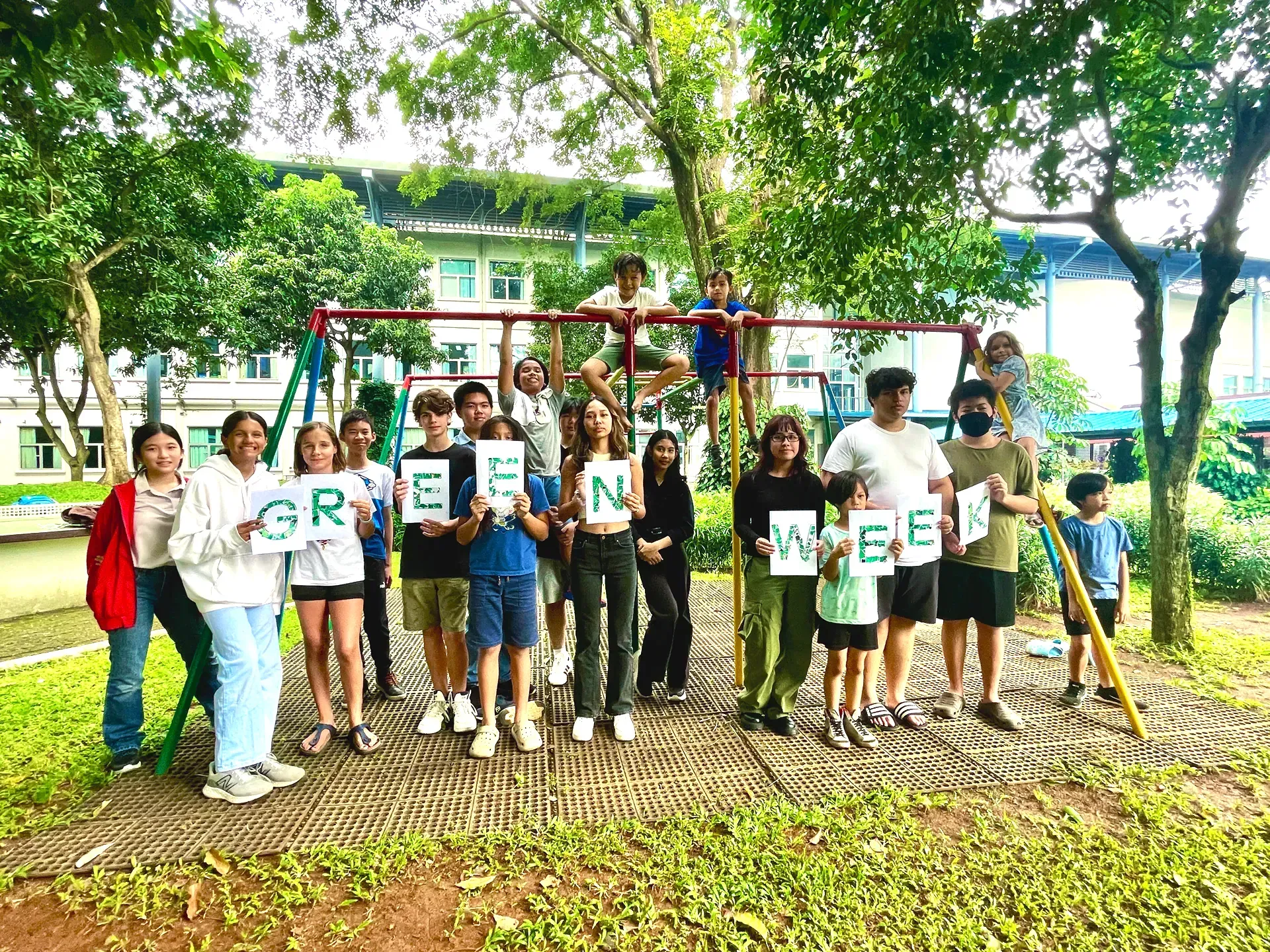 A group of people are standing next to each other in a park holding signs.
