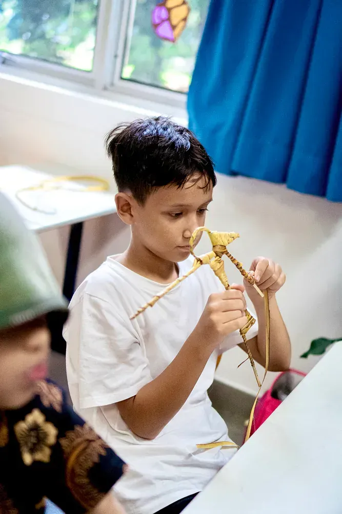 A young boy is sitting at a table playing with a toy.