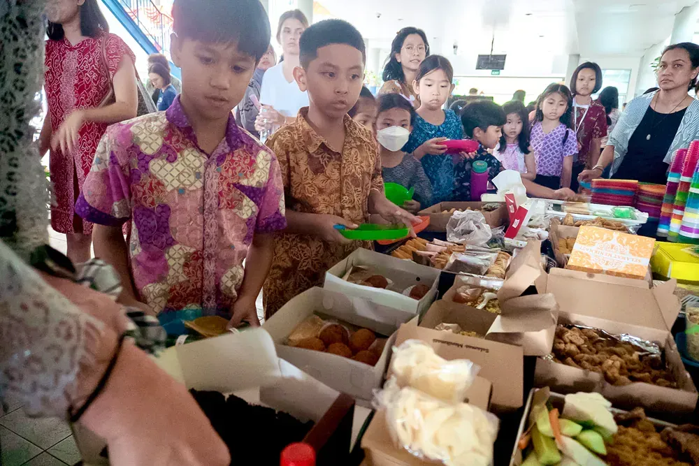 A group of children are standing around a table with boxes of food.