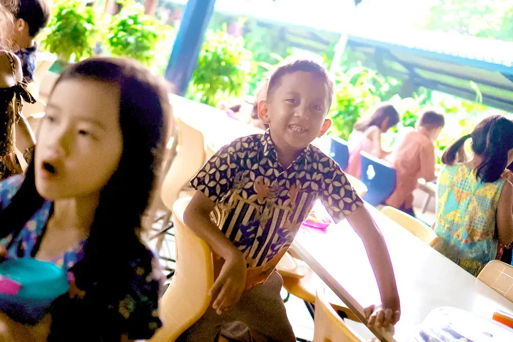 A boy and a girl are sitting at a table in a restaurant.