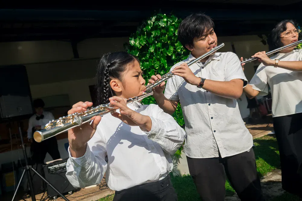 A group of people are playing flutes in a band.