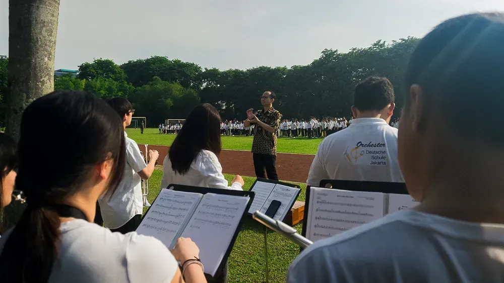 A group of people are standing in a field playing instruments.