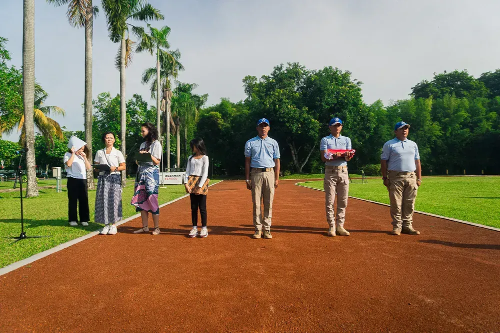 A group of people are standing on a track in a park.