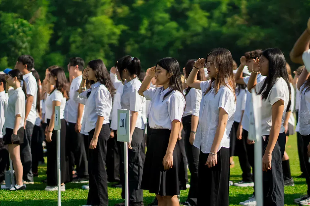A group of students are standing in a line in a field.