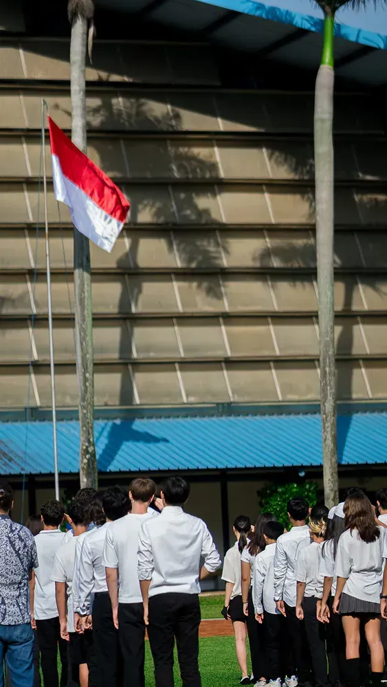 A group of people standing in front of a flag