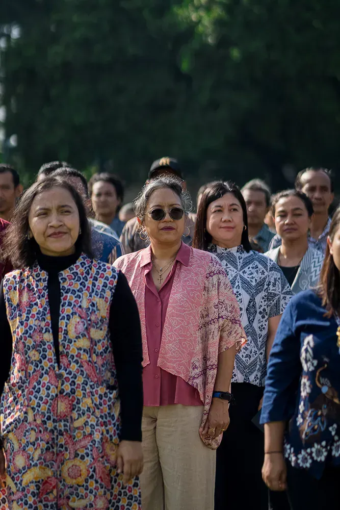 A group of women are standing in a line holding hands.